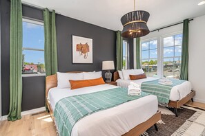 The primary bedroom has 2 queen beds, a smart TV, a closet, and an en-suite bathroom. (3rd Floor)