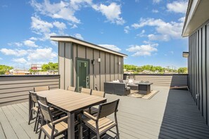 Rooftop deck with fire pit, cornhole, outdoor lounge, and dining area. (4th Floor)