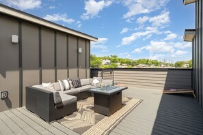 Rooftop deck with fire pit, cornhole, outdoor lounge, and dining area. (4th Floor)