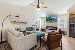 The open living room includes an electric fireplace and smart television.