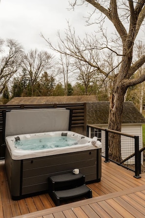 Soak in the hot tub while enjoying peaceful views of the lake and woods