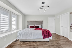 Sleek bedroom with rich burgundy accents and a soft white bed for a cozy retreat