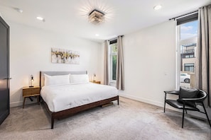 Bright and serene, this bedroom blends soft textures with artistic decor and warm-toned highlights.