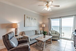 Living area features sleeper sofa, flat screen smart tv, recliner, arm chair and glass sliding doors leading to the private balcony with beachfront ocean views.