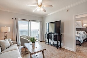 Living area features sleeper sofa, flat screen smart tv, recliner, arm chair and glass sliding doors leading to the private balcony with beachfront ocean views.