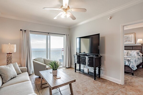 Living area features sleeper sofa, flat screen smart tv, recliner, arm chair and glass sliding doors leading to the private balcony with beachfront ocean views.