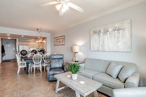 Living area features sleeper sofa, flat screen smart tv, recliner, arm chair and glass sliding doors leading to the private balcony with beachfront ocean views.