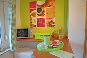 Küchentresen mit Mikrowelle und zweitem Kühlschrank.