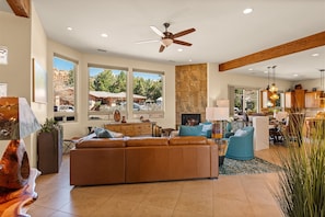 Spacious open concept living area, where rich leather furnishings and a cozy gas fireplace