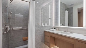 Spacious en suite with a shower, quartz vanity, and luxury bath amenities.