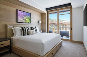 Plush king bed with leather headboard, integrated reading lights, and premium linens