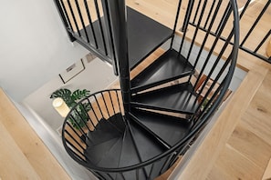 Spiral staircase to office area, bedroom, full bath & laundry