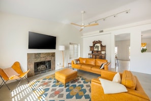 The living room has a working fireplace and a 65-inch TV.