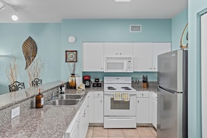 Full kitchen with modern appliances and tropical charm.