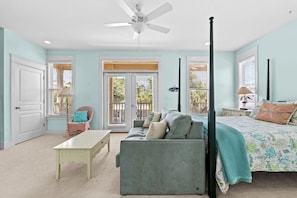 This spacious master bedroom features a plush bed, sitting area, and private balcony perfect for enjoying your morning coffee.
