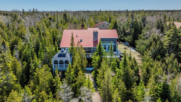 Spacious private lodge surrounded by lush forest, perfect for group getaways and tranquil nature escapes. A unique vacation rental with charming covered decks and scenic views.