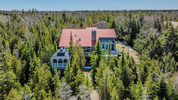 Spacious private lodge surrounded by lush forest, perfect for group getaways and tranquil nature escapes. A unique vacation rental with charming covered decks and scenic views.