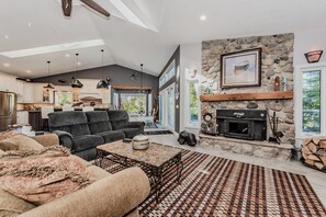 Relax fireside in this cozy, rustic-chic vacation rental. With a stone hearth, comfy seating, and open-concept flow, it's the perfect retreat after lakeside adventures or forest hikes.
