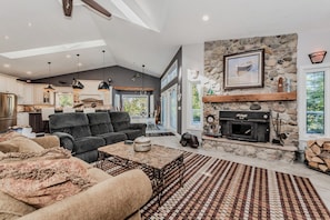 Relax fireside in this cozy, rustic-chic vacation rental. With a stone hearth, comfy seating, and open-concept flow, it's the perfect retreat after lakeside adventures or forest hikes.