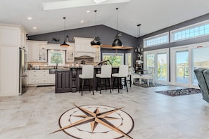 Chef-style kitchen with island seating and forest views—ideal for cooking, gathering, and enjoying your stay. A bright, open vacation rental with all the comforts of home.