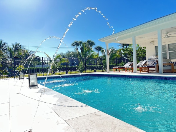 Unwind at this sunny retreat with a heated saltwater pool and stylish outdoor lounge patio — perfect for relaxing, grilling, and soaking up the Florida vibes.