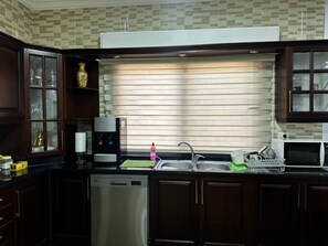 kitchen with washing machine, gas stove, kettle, microwave, filtered water