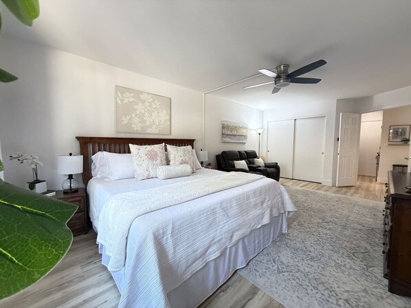 Bedroom with king bed, seating area, smart TV, and closet