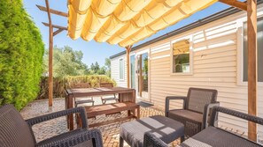 Unwind on the shaded terrace, complete with comfy seating and a rustic dining setup for sunny afternoons. #OutdoorEscape #TerraceVibes #Portugal #PT