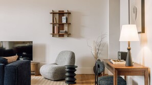 Elegant living area featuring textured chair, wooden desk, subtle lighting, and artistic touches for a sophisticated, cozy ambiance. 
#LivingRoom 
#InteriorStyling 
#DesignDetails
#AndoLiving