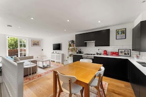 The furnished with stylish chairs surrounding a central table, creating a comfortable and welcoming spot for dining and conversation.