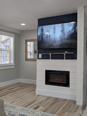 Electric fireplace and smart TV. Full Bathroom is behind that wall