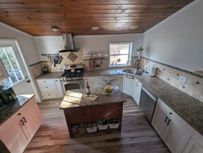 Large kitchen fully equip with tools for everyday cooking, and door to deck.
