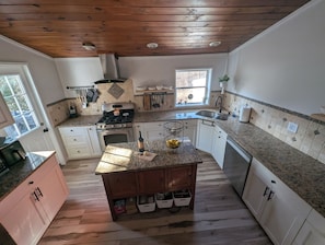 Large kitchen fully equip with tools for everyday cooking, and door to deck.