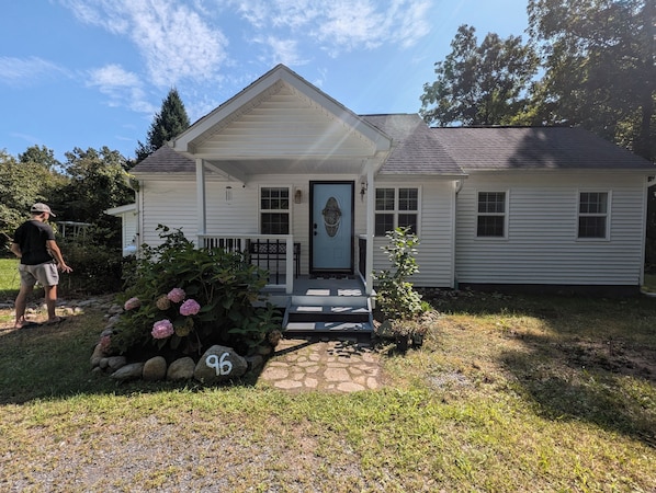 Front entrance go up 3 steps to a covered porch with a 2 person bench