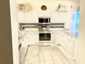Huge open kitchen w/quartz, stainless, breakfast bar, bright sunny windows