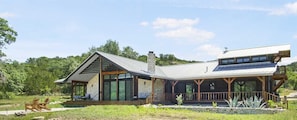 Modern Hill Country retreat with wraparound porch, sleek design, and peaceful views-perfect for your next escape.
