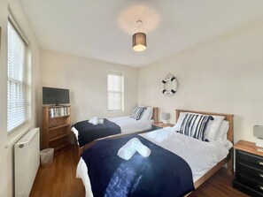 The twin bedroom with portable tv and wardrobes