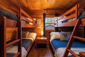 The guest room features two bunk beds: one twin-over-twin and one twin-over-full, offering cozy sleeping space for up to five.
