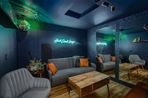 Chill out in the cozy lounge—dark walls, neon vibes, and a disco ball set the mood for unforgettable nights.