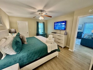 Main Bedroom with a king size bed, smart TV, desk, and attached full bathroom.