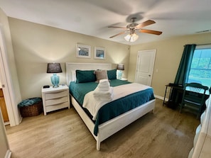 Main Bedroom with a king size bed, smart TV, desk, and attached full bathroom.