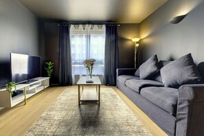 The living room features with a 50'' smart TV and a comfortable 3-seater sofa.