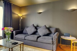 The living room features with a 50'' smart TV and a comfortable 3-seater sofa.