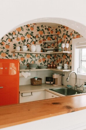 A bright, colorful peach-themed kitchen has all the essentials to make a cozy meal.