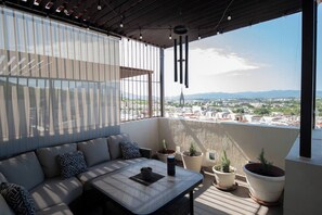 The terrace or balcony is equipped with a sofa a table, a hammock with great city views