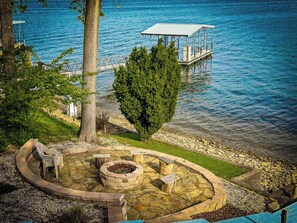 Discover your own lakeside retreat with this property featuring a charming stone fire pit area perfect for outdoor gatherings by the water's edge. Enjoy the convenience of a private boat dock, offering easy access to the beautiful lake for endless recreational opportunities.