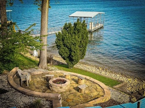 Discover your own lakeside retreat with this property featuring a charming stone fire pit area perfect for outdoor gatherings by the water's edge. Enjoy the convenience of a private boat dock, offering easy access to the beautiful lake for endless recreational opportunities.