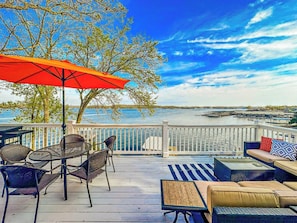 Imagine relaxing on this expansive deck overlooking the sparkling water, perfect for entertaining guests or enjoying peaceful moments. This stunning outdoor space offers ample seating, an umbrella for shade, and breathtaking waterfront views, making it an ideal extension of your living area.