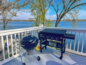 This lakefront property boasts a fantastic deck perfect for outdoor cooking and entertaining, featuring both a classic charcoal kettle grill and a convenient flat-top propane griddle. Imagine grilling your favorite meals while enjoying the stunning views of the sparkling water.
