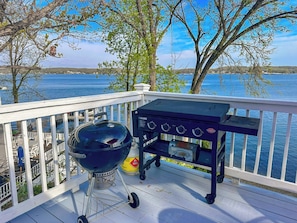 This lakefront property boasts a fantastic deck perfect for outdoor cooking and entertaining, featuring both a classic charcoal kettle grill and a convenient flat-top propane griddle. Imagine grilling your favorite meals while enjoying the stunning views of the sparkling water.